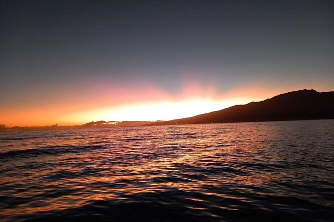 Sunset sailing trip on the Lagoon of Tahiti - Polynesian double canoe, sunset colors, and Moorea views